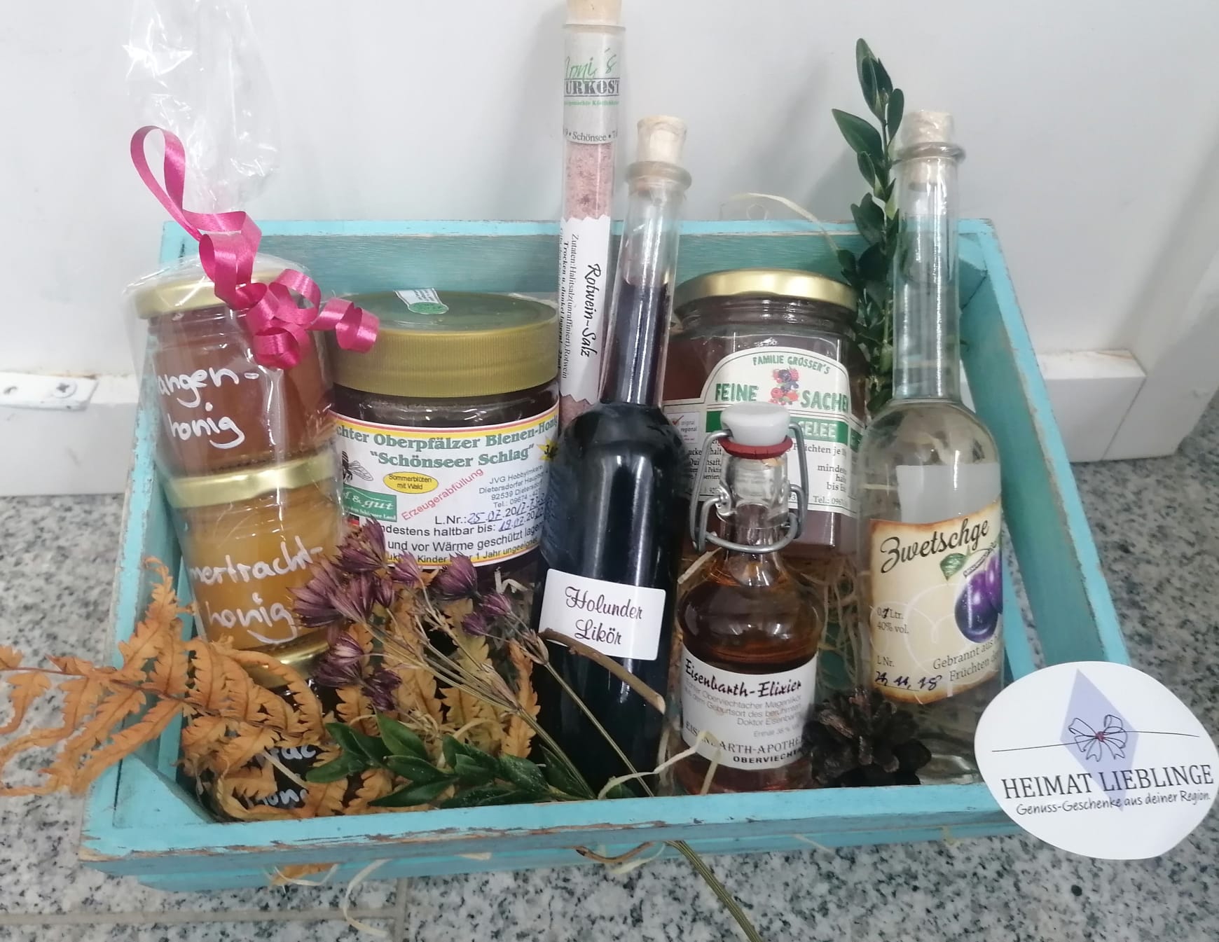 Eine hellbaue Holzkiste, gefüllt mit lolkalen Leckereien