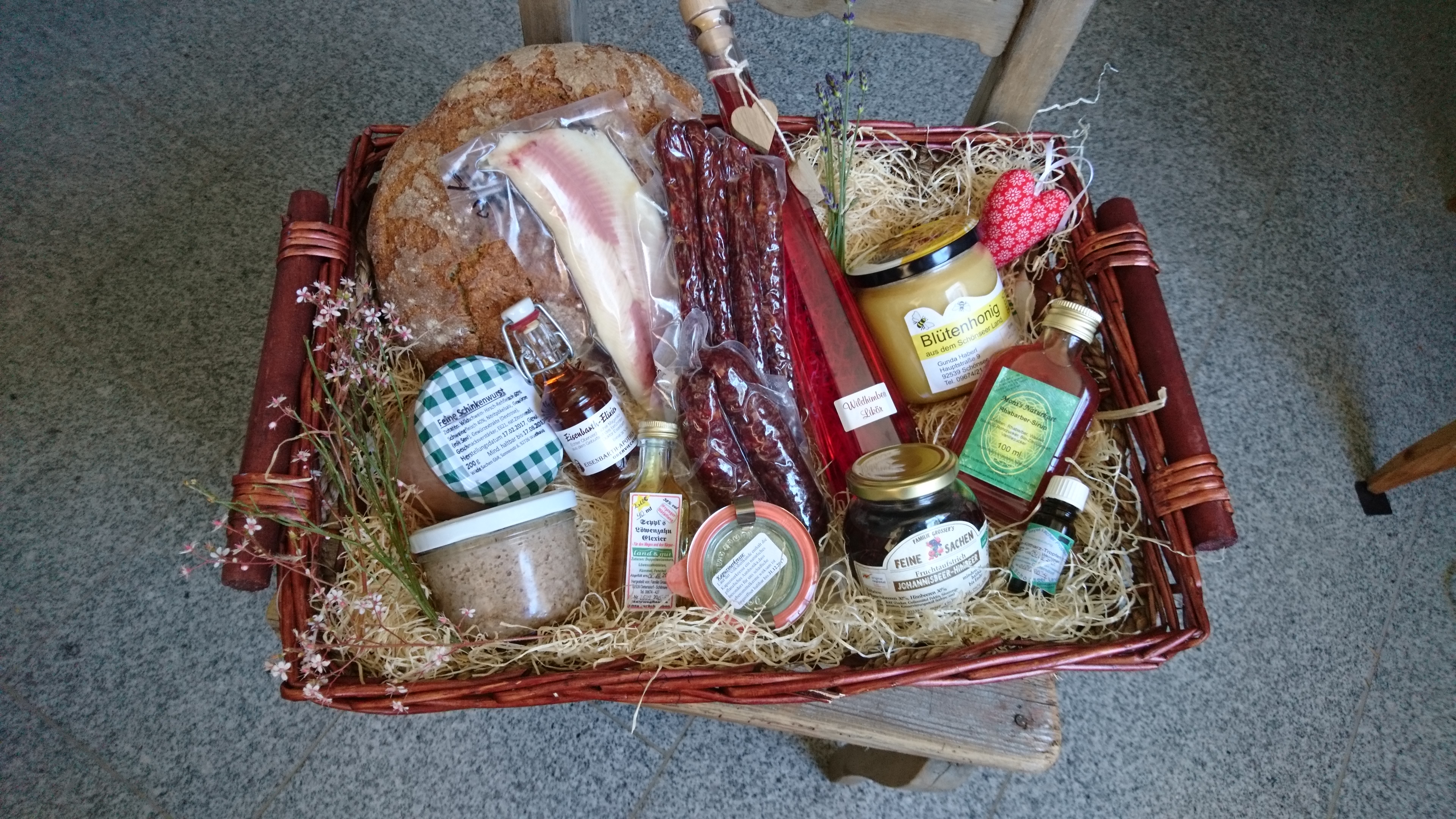 Geschenkkorb aus geflochtenen Weiden, gefüllt mit lokalen Leckereien