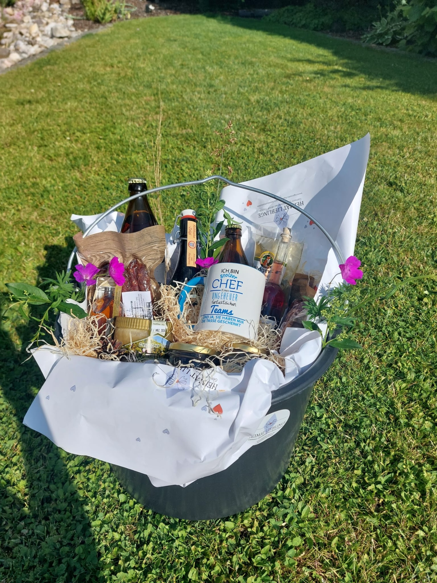 Ein Eimer gefüllt mit lokalen Leckereien, auf einer grünen Wiese